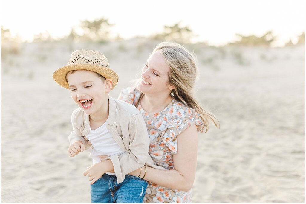 Mom joyfully tickles her son on the beach in rehoboth, delaware