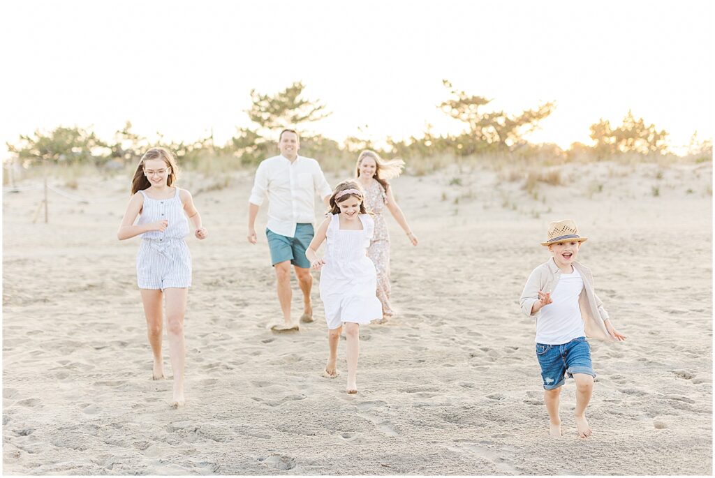 Kids run towards their Rehoboth beach family photographer during their family beach session