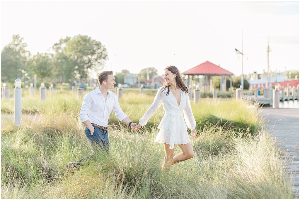 couple walking through the grass in canal front park, lewes, delaware